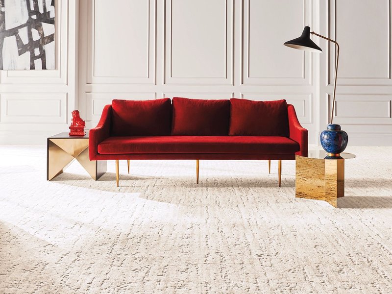 a red sofa on a beige soft carpet floor from Sams Floor Covering in Winchester, KY